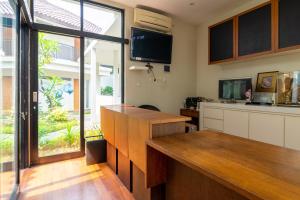 a kitchen with a counter and a tv on the wall at RedDoorz near Transmart Kalimalang in Jakarta