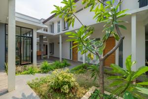 an exterior view of a house with trees and plants at RedDoorz near Transmart Kalimalang in Jakarta