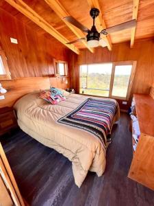 een slaapkamer met een groot bed in een houten kamer bij Mandala Tiny House, Traslasierra. in Yacanto