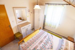 1 dormitorio con cama y espejo en Apartments by the sea Okrug Donji, Ciovo - 15655 en Donji Okrug