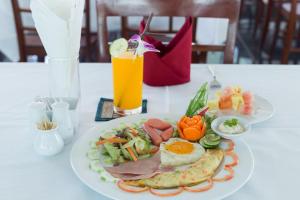 a plate of breakfast food on a table with a drink at Melody Boutique Hotel in Siem Reap