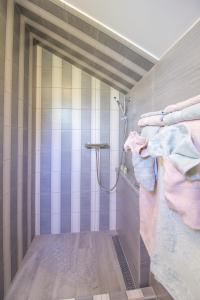 La salle de bains est pourvue d'une douche avec des rayures roses et bleues. dans l'établissement Apartments by the sea Okrug Donji, Ciovo - 15655, à Okrug Donji