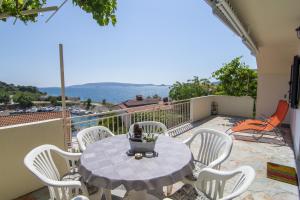 eine Terrasse mit einem Tisch und Stühlen auf dem Balkon in der Unterkunft Apartments by the sea Okrug Donji, Ciovo - 15655 in Okrug Donji