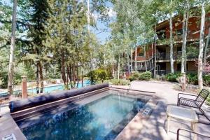 a swimming pool with two chairs next to a building at Snowmass Village, 4 Bedroom at the Enclave - Ski-in Ski-out in Snowmass Village