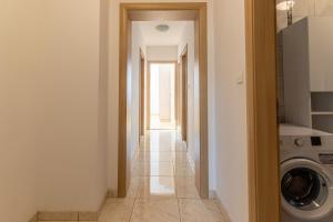 a hallway of a house with a washing machine at Family friendly apartments with a swimming pool Sutivan, Brac - 15665 in Sutivan