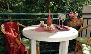 a white table with a bottle of wine and a glass at Apartments by the sea Podaca, Makarska - 15685 in Podaca