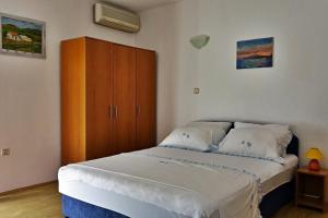 Schlafzimmer mit einem Bett und einem Holzschrank in der Unterkunft Apartments by the sea Podaca, Makarska - 15685 in Podaca