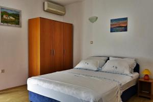 a bedroom with a bed and a wooden cabinet at Apartments by the sea Podaca, Makarska - 15685 in Podaca
