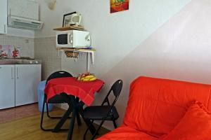 a kitchen with a table with a red blanket on it at Apartments by the sea Podaca, Makarska - 15685 in Podaca +22 photos