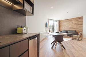 a kitchen with a table and a living room at Grand Suites Lake Tekapo in Lake Tekapo