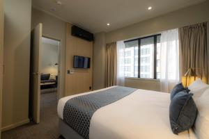 a hotel room with a large bed and a window at Quest 256 Lambton in Wellington