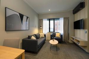 a living room with a couch and a table at Quest 256 Lambton in Wellington