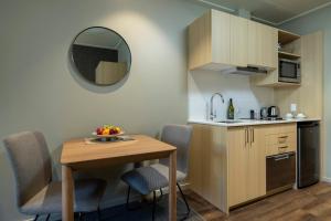 a small kitchen with a table and a mirror at Quest 256 Lambton in Wellington