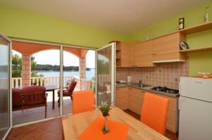 a kitchen with orange chairs and a table with a view at Apartments by the sea Karbuni, Korcula - 15699 in Prizba