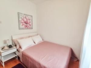 a small bedroom with a bed and a night stand at Apartments with a parking space Smrika, Kraljevica - 15700 in Šmrika