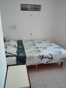a bed in a room with a blanket on it at Apartments by the sea Bibinje, Zadar - 15707 in Bibinje