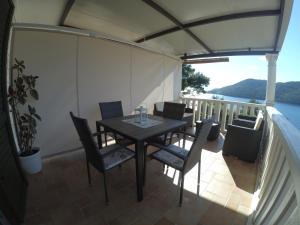 eine Terrasse mit einem Tisch und Stühlen auf dem Balkon in der Unterkunft Apartments by the sea Brna, Korcula - 15730 in Smokvica