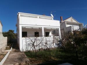 een wit gebouw met zijn deur open voor een huis bij Apartments by the sea Sevid, Trogir - 15742 in Sevid
