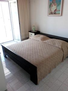 a large bed in a bedroom with a large window at Apartments by the sea Sevid, Trogir - 15742 in Sevid