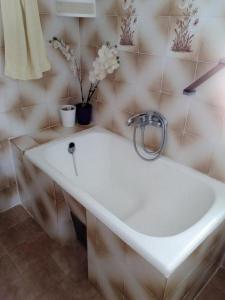 uma casa de banho com um lavatório branco e flores numa parede em Apartments by the sea Sevid, Trogir - 15742 em Sevid