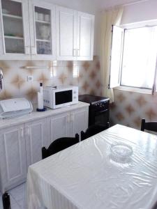 a kitchen with a white table and a microwave at Apartments by the sea Sevid, Trogir - 15742 in Sevid