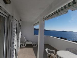 een balkon met uitzicht op de oceaan vanuit een huis bij Apartments by the sea Sevid, Trogir - 15742 in Sevid