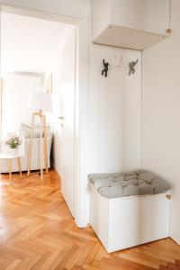 a white room with a bench in front of a door at White Apartment in Ljubljana