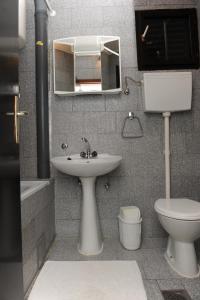 a bathroom with a sink and a toilet and a mirror at Apartment Podaca 15748c in Podaca
