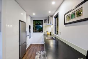uma cozinha com paredes brancas e um longo corredor em The Twins em Queenstown