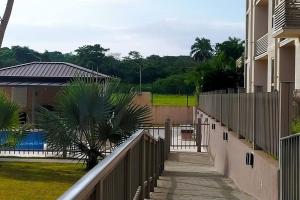 Un balcón de una casa con una valla y una piscina en Apartamento de 1 recamara en Panama Pacifico, en ArraijÃ¡n