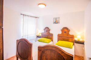 two beds in a white room with yellow pillows at Apartments by the sea Vrbnik, Krk - 15754 in Vrbnik