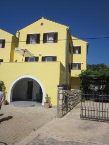 a yellow building with an archway in front of it at Apartments by the sea Nerezine, Losinj - 15778 in Nerezine