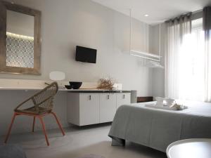 een slaapkamer met een bed, een stoel en een televisie bij Ca' D'Andrean in Manarola