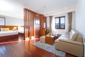 a hotel room with a couch and a bed at Sunny Ocean Hotel & Spa in Danang +36 photos