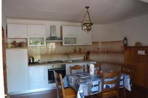 a kitchen with a table and a kitchen with white cabinets at Seaside holiday house Sutomiscica, Ugljan - 15965 in Preko