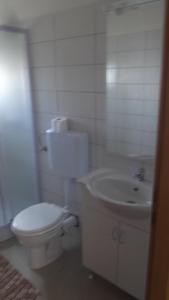 biała łazienka z toaletą i umywalką w obiekcie Apartments with WiFi Podstrana, Split - 15970 w Podstranie