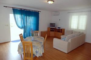 a living room with a table and a couch at Apartment Supetarska Draga - Donja 15983c in Rab