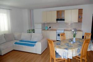 ein Wohnzimmer mit einem Sofa und einem Tisch mit Stühlen in der Unterkunft Apartment Supetarska Draga - Donja 15983c in Rab