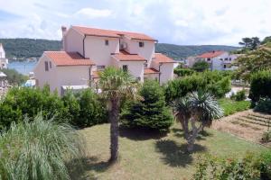 a large house with palm trees in a yard at Apartment Supetarska Draga - Donja 15983c in Rab