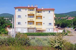 duży biały budynek przy drodze w obiekcie Apartments with a parking space Klenovica, Novi Vinodolski - 15987 w mieście Klenovica