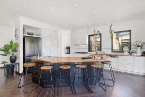 a kitchen with a large island with stools at Sandstone Estate in Red Hill