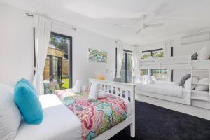 a white bedroom with two bunk beds and a window at Sandstone Estate in Red Hill