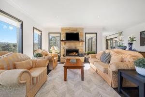 a living room with two couches and a fireplace at Sandstone Estate in Red Hill