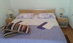 una camera da letto con letto e lenzuola e cuscini viola di Apartments by the sea Sobra, Mljet - 15993 a Babino Polje