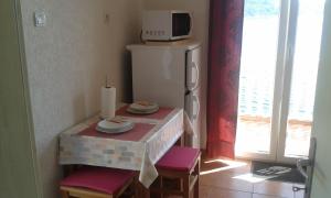 a small kitchen with a table and a refrigerator at Apartments by the sea Sobra, Mljet - 15993 in Babino Polje