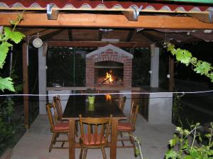 a table and chairs with a fireplace on a patio at Apartments with parking space Supetarska Draga - Donja, Rab - 15999 in Rab