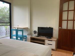 1 dormitorio con 1 cama y mesa con TV en 老老街 誠君民宿, en Fenchihu