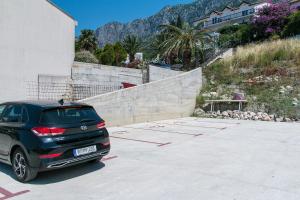 a car parked in a parking lot next to a building at Rooms by the sea Gradac, Makarska - 16006 in Gradac
