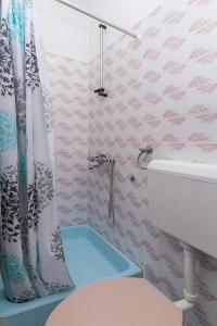 bagno con tenda per la doccia e servizi igienici di Triple Room Gradac 16006c a Gradac (Grado)