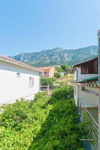 uma mulher de pé na varanda de um edifício em Rooms by the sea Gradac, Makarska - 16006 em Gradac